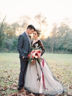 a bride and groom are standing in the leaves outside on their wedding day at sunset