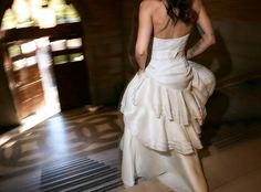 a woman in a white dress is standing on the floor with her back to the camera