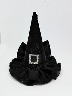 Miniature witch hat for babies, girls, adults and pets. Mini hat size is approximately 3.5 inches wide by 4 inches tall. Mini hat can be attached to a metal alligator clip, a soft elastic headband, or ribbon for pets. Please choose the finish: -2.6 inches alligator clip  -5/8 by 16 or 18 inches soft elastic headband  -3/8 by 18 or 25 inches ribbon (for pets) Finish color: -Metal Clip -Black  -Gray  -There may be slight variation in size  -Due to lighting color may vary slightly  -Miniature hats Halloween Costume Hat Accessories, Halloween Costume Hat, Halloween Novelty Mini Costume Hat, Witchy Costume Hats And Headpieces For Party, Witchy Mini Hats With Curved Brim For Party, Witchy Style Mini Hats With Curved Brim For Party, Brimmed Black Mini Hats For Costumes, Black Brimmed Mini Hats For Costumes, Whimsical Halloween Costume Hats And Headpieces As Gift