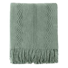 a green blanket with fringes on it