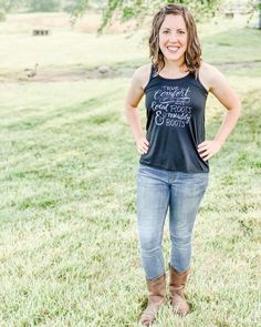 a woman standing in the grass with her hands on her hips