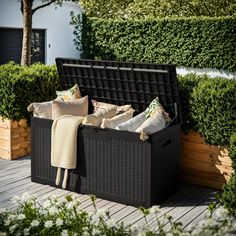 an outdoor storage bench with pillows and blankets