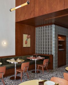 an empty restaurant with wood paneling and tiled walls, tables and chairs in the center