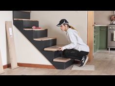 a woman is sitting on the stairs in her home