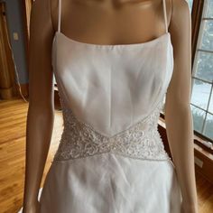 a white wedding dress on display in front of a window