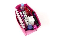 a pink bag filled with lots of different types of cosmetics and personal care items on top of a white surface