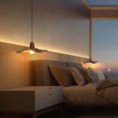 a bedroom with a large window overlooking the city at night, and two lamps on either side of the bed