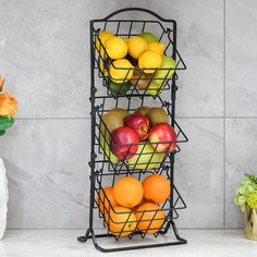 three tiered metal fruit basket with apples, oranges and lemons in it