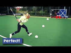 a woman swinging a tennis racquet on top of a green field next to white balls