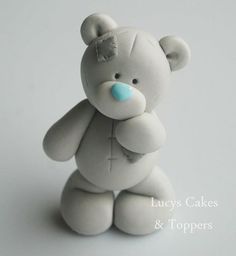 a gray teddy bear sitting on top of a white table