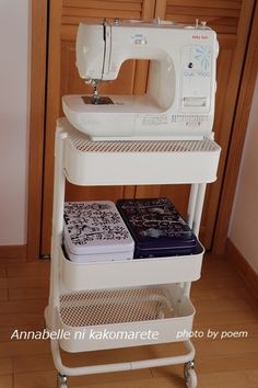 a white sewing machine sitting on top of a shelf