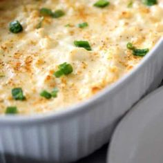 a casserole dish with green onions and cheese