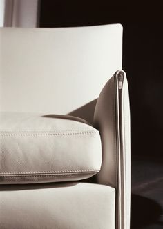 a close up of a white leather chair with zippers on the arm and back