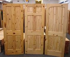 three wooden doors are stacked on top of each other in a room filled with furniture