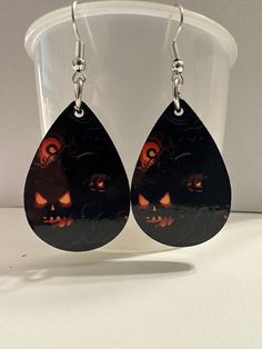 Spooky Pumpkins Earrings Handmade item - sublimated design is on both sides and attached with silver metal earwire Drop Length from ear: 2 inches Length: 1.5 Inches  Width: 1 Inches These spooky pumpkin earrings are lightweight and comfortable, making them perfect for Halloween season. ~ PROCESSING TIME ~ Allow 2-4 business days for production. Allow 3-5 business days for shipping. (Usually 2-3 but please allow a few extra days to due USPS processing times) ~ SHIPPING ~ All orders ship via First Class or Priority USPS with tracking and usually 3-5 days in mail transit.  Please make sure your address is correct at checkout to avoid shipping delays.  We are NOT responsible for packages shipped to an old OR incorrect address given by the buyer.  It is important to double check your shipping a Nickel Free Halloween Party Earrings, Nickel Free Earrings For Halloween Party, Halloween Teardrop Jewelry Gift, Dangle Earrings As Halloween Gift, Halloween Dangle Earrings, Black Drop Earrings For Halloween, Dangle Earrings For Halloween Gift, Halloween Spooky Ear Wire Earrings, Black Halloween Earrings Gift