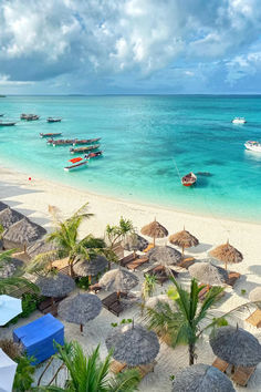 the beach is lined with umbrellas and boats