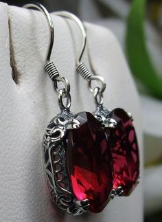 Simulated Red Ruby Solid Sterling Silver Earrings Edward Design#E70 This is a pair of antique-inspired Edwardian style earrings. The flawless oval simulated red Ruby gems are surrounded by delicate sterling silver filigree. The lovely full cut oval stones are approximately 14mm by 10mm in length & width. The earrings are 1.25 inches long and are marked 925 for solid sterling silver. Notice the beautiful floral craftsmanship of the filigree settings. The gemstones are cut to reflect light, cr Red Sterling Silver Filigree Earrings, Ornate Red Sterling Silver Earrings, Red Ruby Earrings With Intricate Design, Ornate Oval Red Jewelry, Red Oval Garnet Earrings, Red Garnet Oval Earrings, Victorian Red Oval Earrings, Red Ruby Earrings, Edwardian Jewelry