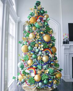 a brightly colored christmas tree in a white living room with green and gold ornaments on it