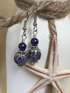 Life is short - wear pretty things! A beautiful pair of purple & olive speckled dangle earrings that will be a great wardrobe accessory. Also a great gift idea. Earrings are made using surgical steel ear wires. I use wrapped loops to give the earring a more finished look. Earrings come with rubber ear backs that slide on to keep earrings from falling out of ears. Color: dark purple, olive green, Deep purple pearl, Earrings length: 1 3/4 inches YOU MAY ALSO LIKE: https://www.etsy.com/shop/Jil Czech Glass Earrings With French Hook For Gift, Purple Round Beaded Jewelry For Mother's Day, Hypoallergenic Czech Glass Jewelry, Purple Dangle Beaded Earrings For Gift, Purple Dangle Beaded Earrings As Gift, Adjustable French Hook Earrings As Gift, Hypoallergenic Czech Glass Beaded Earrings For Gift, Hypoallergenic Czech Glass Earrings For Gift, Adjustable Purple Jewelry With Lever Back Ear Wires