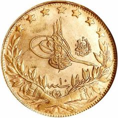 an old gold coin with arabic writing and stars on the reverse, in front of a white background