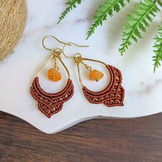 Carnelian and gold earrings with a rich mahogany orange macrame detail. Handmade to order with love 💕 ❃ 1 pair of macrame earrings featuring an Carnelian chip bead. ❃ These earrings come with vacuum plated gold stainless steel ear wires ❃ Knotted with durable, nylon cord (mahogany) ❃ Choose your ear hook style. (All hooks come with clear backings except for the closable hooks) :  1.  Gold stainless steel french hooks: The finish is vacuum plated for a durable gold finish. 2. Leverback: These hooks latch in the back for a secure fit. Also vacuum plated gold finish. 3. Plastic hooks: These are made of a flexible clear plastic. Perfect for sever metal allergies. ❧ All accessories by Hang Loose Creations are uniquely handcrafted, using deep-rooted macrame techniques ❧ With Boho designs and he Handmade Carnelian Orange Earrings, Handmade Adjustable Carnelian Earrings, Handmade Orange Carnelian Earrings, Bohemian Orange Brass Jewelry, Bohemian Gold Carnelian Earrings, Gold Bohemian Carnelian Earrings, Bohemian Carnelian Dangle Earrings, Bohemian Carnelian Amber Earrings, Bohemian Amber Carnelian Earrings