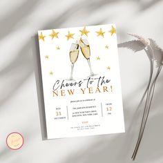 cheers to the new year party card with champagne glasses and stars on it, next to some flowers