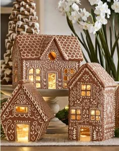 three gingerbread houses are lit up with lights