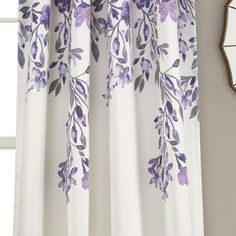 a window with purple flowers on it next to a mirror