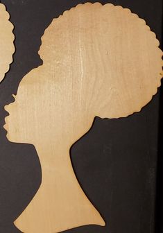 a wooden cutout of a woman's head in profile, with the hair pulled back