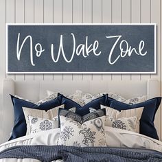 a bed with blue and white comforters in front of a sign that says no wake zone