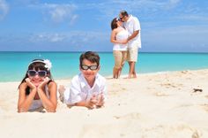 three people laying on the beach with sunglasses