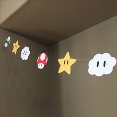 a nintendo themed garland with mario and luigi's heads hanging from the ceiling in a room