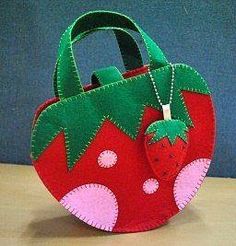 a handbag made out of felt with a strawberry on the front and green leaves on the back