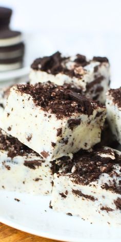 several pieces of cake sitting on top of a white plate next to some chocolate cookies