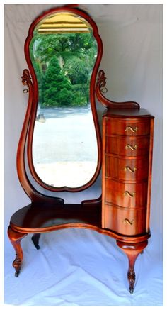 an antique dresser with a mirror on it