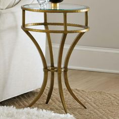 a glass table with a bottle of wine on it in front of a white couch