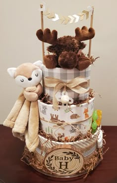 a diaper cake with teddy bears and other items on it's top tier