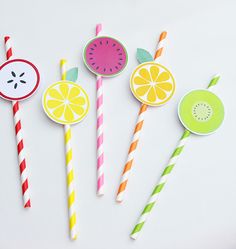 four paper straws with fruit designs on them and one has a slice of watermelon