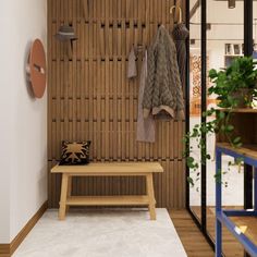 a wooden bench sitting in front of a wall with coat racks on it's sides