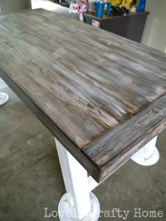 a wooden table sitting on top of a white pedestal