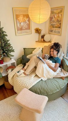 two children are sitting on a bean bag chair in the living room and one is reading a book