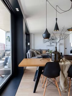 a dining room table with black chairs next to a couch