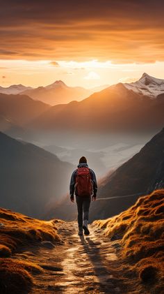 a man with a backpack walking up a trail towards the mountains