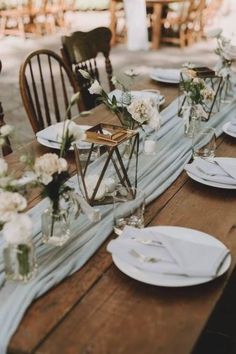 the table is set with white plates and place settings for an elegant dinner party or reception