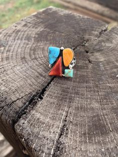 Expertly crafted by Native American artist Jimson Belin, this freeform multi-color ring is a stunning piece of .925 silver jewelry. Adorned with red corral, orange spiny oyster, green turquoise, and blue turquoise, this handcrafted ring is a one-of-a-kind treasure that will add a touch of beauty and uniqueness to any outfit. Handmade Artisan Multicolor Turquoise Ring, Handmade Multicolor Artisan Turquoise Ring, Spiritual Multicolor Multi-stone Rings, Artsy Sterling Silver Multicolor Jewelry, Unique Orange Ring Jewelry, Artsy Multicolor Sterling Silver Jewelry, Bohemian Orange Jewelry Ring, Artisan Multicolor Turquoise Ring With Natural Stones, Artisan Multicolor Ring Jewelry