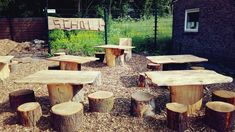 a group of wooden tables and benches sitting in the middle of a park