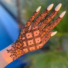 a woman's hand with henna tattoos on it