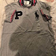 Gray And Black And Red Polo Shirt Very With Ref Strips On The Arms Very Nice Gray Short Sleeve Sporty Polo Shirt, Gray Sporty Short Sleeve Polo Shirt, Casual Gray Polo Collar Shirt, Ralph Lauren Shirts Men, Clothes Board, Pink Polo Shirt, Polo Outfit, Royal Blue Shorts, Red Polo Shirt