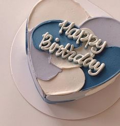 a blue and white heart shaped cake with the words happy birthday written on it's side