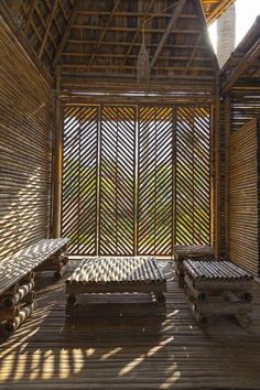 the inside of a bamboo hut with wooden benches and wood slats on the floor